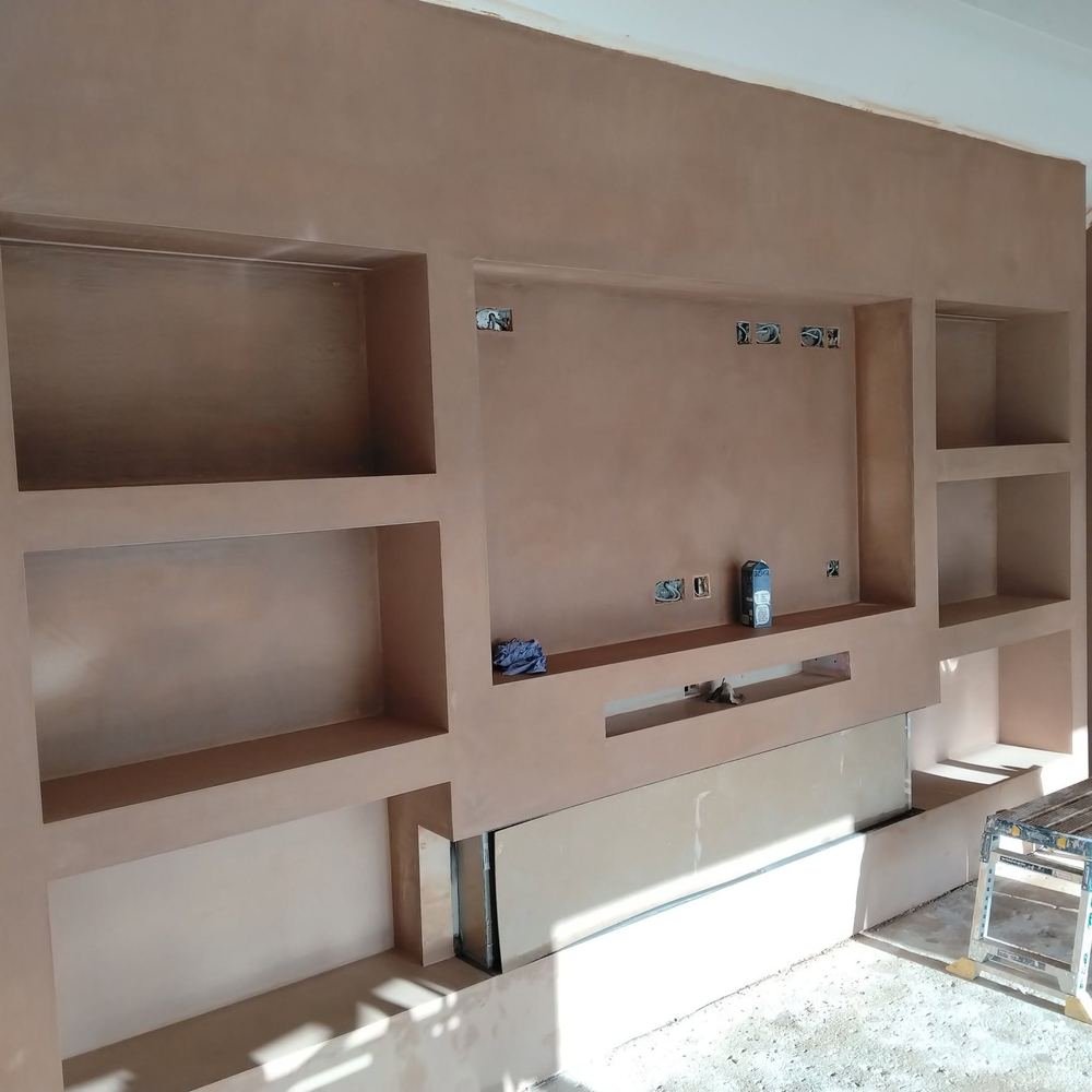A media wall with built-in alcoves, plastered and ready for decorating
