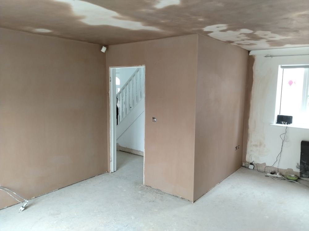 A plastered room corner with a doorway, walls and ceiling finished